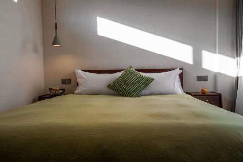a bedroom with a large bed with two pillows at 大理沙溪云喜七月精品客栈 Shaxi Ancient Town Yunxi Qiyue Guesthouse in Jianchuan