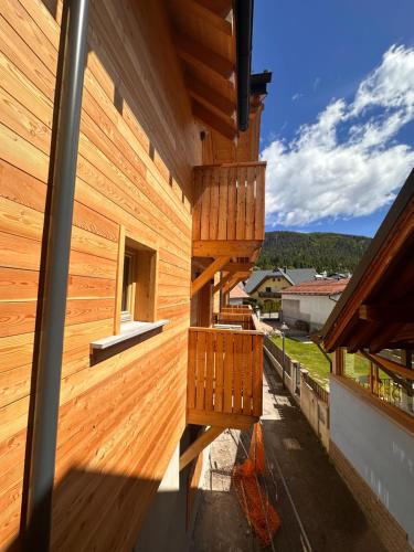 a wooden house with a balcony with a view at Lussari Style Apartments in Camporosso in Valcanale