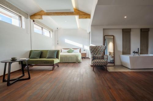 a living room with a couch and a bed and a tub at 大理沙溪云喜七月精品客栈 Shaxi Ancient Town Yunxi Qiyue Guesthouse in Jianchuan