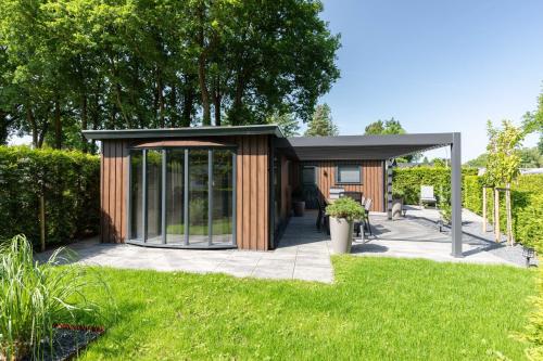 a small shed with a canopy in a yard at Bosrijk Austerpark chalet 29 in Putten