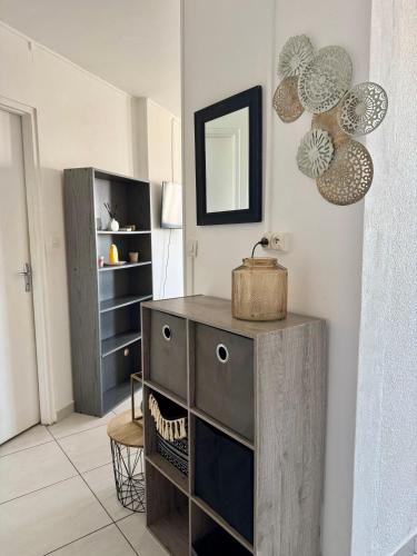 - une cuisine avec un meuble en bois et un miroir dans l'établissement Pause a Mare Nostrum - Histoire de clés, au Cap d'Agde