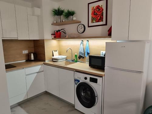 a kitchen with a sink and a washing machine at Апартамент 10 улица Македония 33 in Pomorie