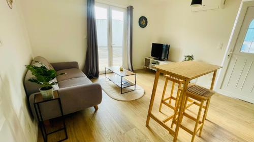 un salon avec un canapé et une table dans l'établissement T2 climatisé proche Dune du Pilat, à La Teste-de-Buch
