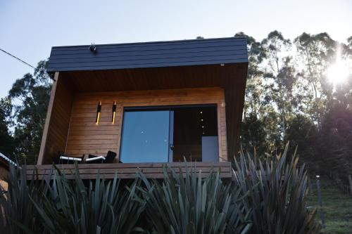 a tiny house with a large window on a deck at Refúgio de Altitude in Urupema