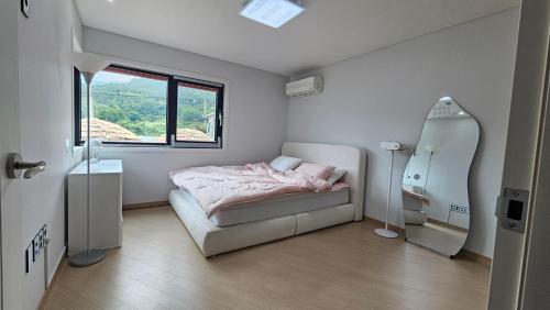 a small bedroom with a bed and a mirror at Yeon Stay Miryang in Miryang