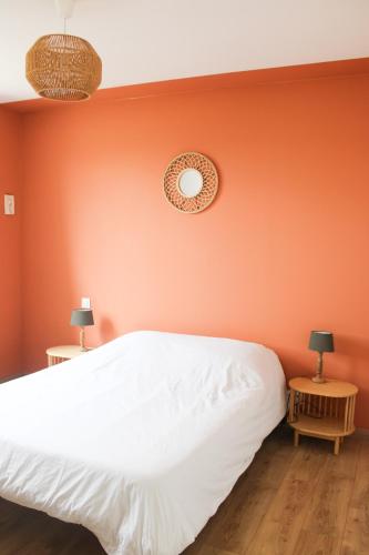 - une chambre dotée d'un mur orange avec un lit et deux lampes dans l'établissement Gîte le Puy Pin, 4 personnes, à Sevremont