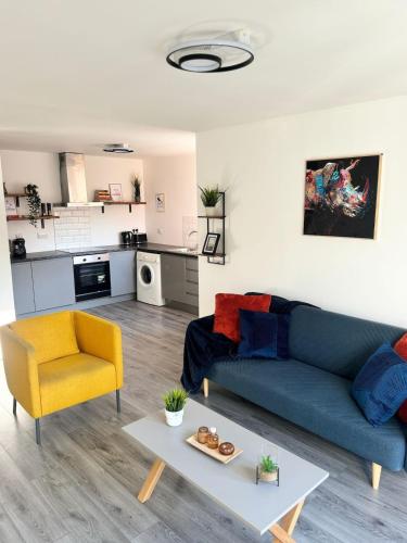 a living room with a blue couch and a yellow chair at Modern living Apartment in West Bromwich