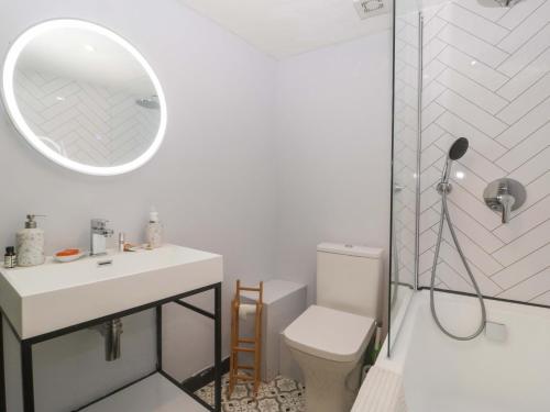 un bagno con un water, un lavandino e uno specchio di Elm Cottage a Moreton in Marsh