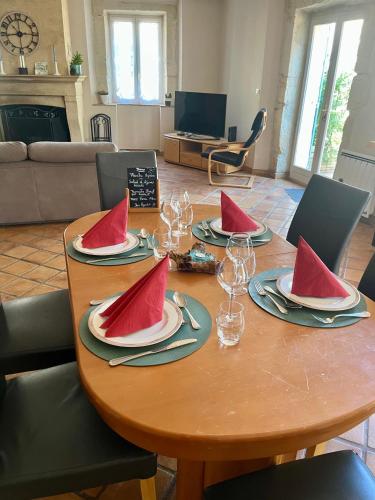 a table with watermelon plates and wine glasses on it at Le colibri bleu in Argeliers
