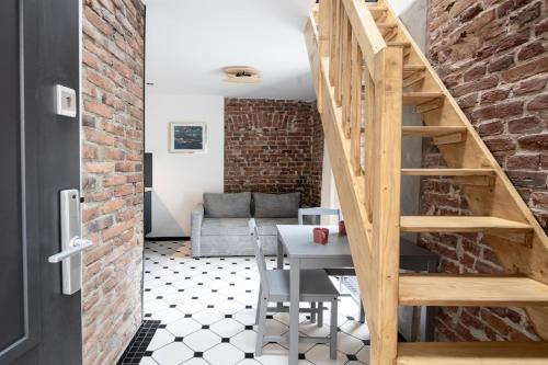 a dining room with a table and a brick wall at Polpo Apartments B&B in Łódź