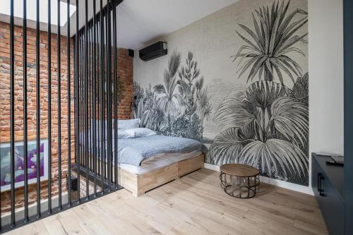 a bedroom with a bed with a mural of plants at Polpo Apartments B&B in Łódź