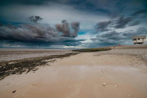 a dirt road leading to a building on a beach at The Midland in Morecambe