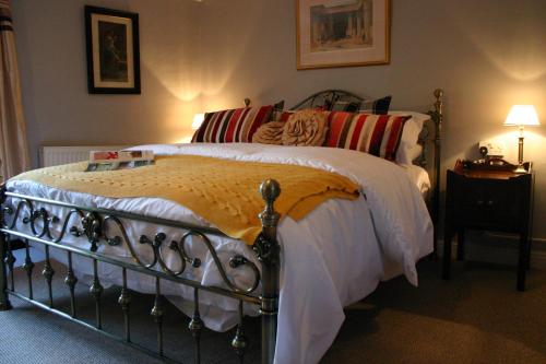 
a bed with a white bedspread and pillows at Horse & Groom B&B in Westbury
