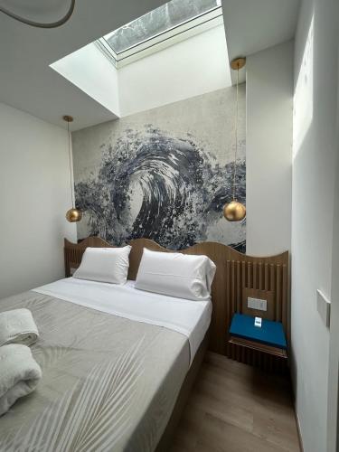 a bedroom with a bed with a painting on the wall at Hotel Ficocella in Palinuro