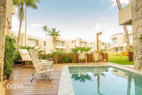 eine Terrasse mit Stühlen und einem Swimmingpool in der Unterkunft Casa Anamá em condomínio Naluum H9 by Qavi in Passo de Camarajibe