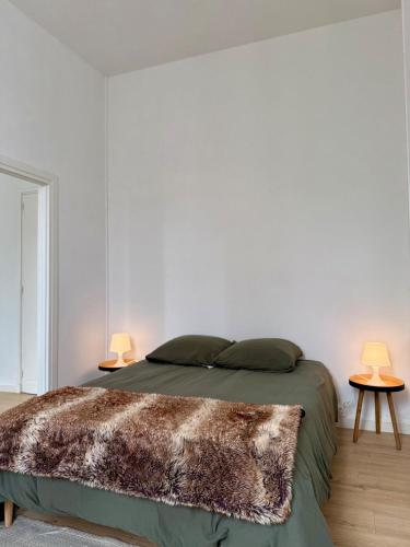 - une chambre avec un lit et deux lampes sur deux tables dans l'établissement Appartement proche mer, à Royan