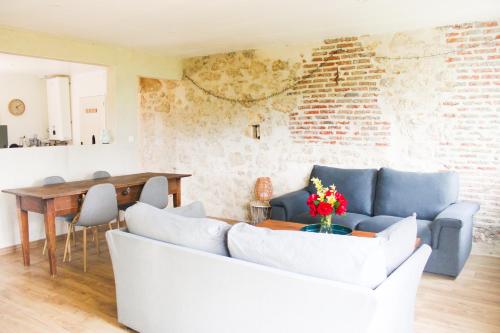 un salon avec un canapé et une table dans l'établissement Gîte le Puy Pin, 4 personnes, à Sevremont