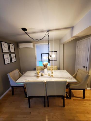 a dining room with a white table and chairs at Modern Sweet Home in Roberval