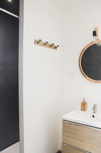 une salle de bain avec un lavabo et un miroir dans l'établissement Gîte le Puy Pin, 4 personnes, à Sevremont