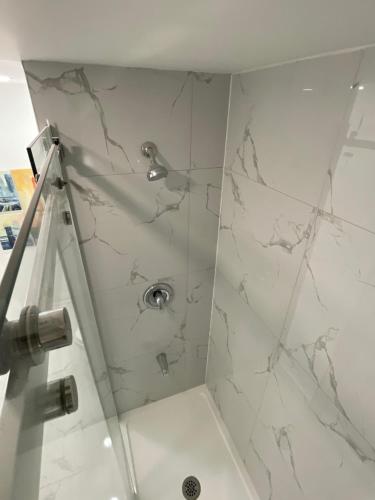 a bathroom with a shower with white marble at Executive Apartment - 2BDR Parking Self-check in - Walkout basement Lower Unit in Mississauga