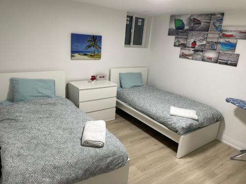 a bedroom with two beds and a dresser in it at Executive Apartment - 2BDR Parking Self-check in - Walkout basement Lower Unit in Mississauga