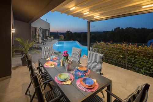 a table with plates of food on a patio at Residence Villa Manuela - Pool & Jacuzzi - Batlug in Batlug
