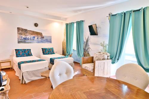 a living room with a couch and a table at Il Saracino boutique suites in Capraia