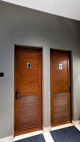 two wooden doors in a room with a wall at Royal Lion Hotel - Kandy Road, Galagadara in Galagedara