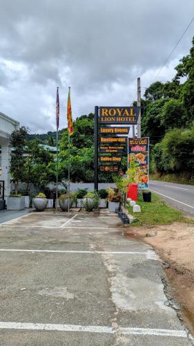 a sign in a parking lot next to a road at Royal Lion Hotel - Kandy Road, Galagadara in Galagedara