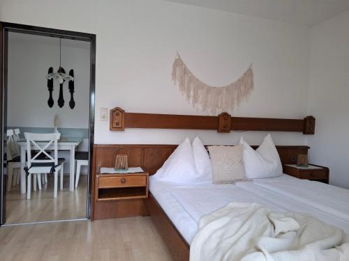 a bedroom with a bed and a table and a mirror at Wohnen im NATURNEST in Podersdorf am See