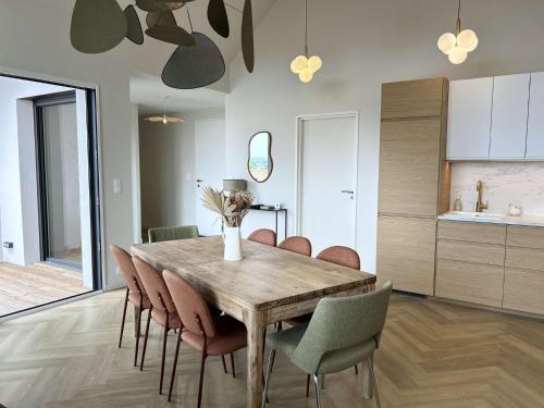 une salle à manger avec une table et des chaises en bois dans l'établissement 765 - Maison moderne avec piscine privative., à Erquy