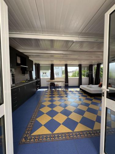 a kitchen with a blue and yellow checkered floor at House Mariona in Caminha