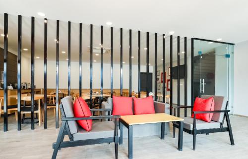 a room with two chairs and a table with red pillows at Super Townhouse Prithvi Resort Near Phoenix Palassio in Lucknow