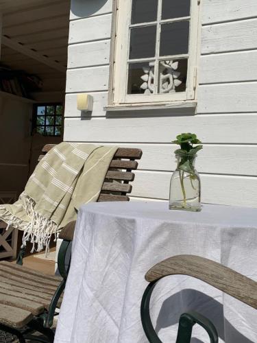 a table with a vase on top of it next to a window at Havsnära sommarhus på Älgö in Saltsjöbaden