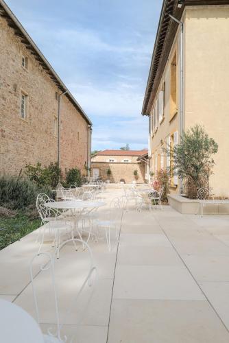 un groupe de tables et de chaises sur un trottoir dans l'établissement Château du Bost, 21 personnes, piscine, Beaujolais, Blacé proche Lyon, à Blacé