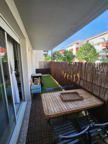 d'une terrasse avec une table et des chaises en bois sur un balcon. dans l'établissement appartement terrasse Montpellier, à Montpellier