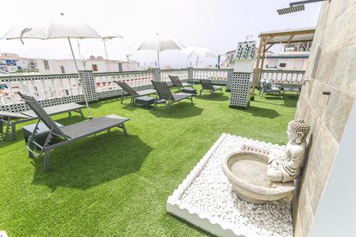 a patio with chairs and a fountain on a roof at Marimel Nerja Alojamientos in Nerja