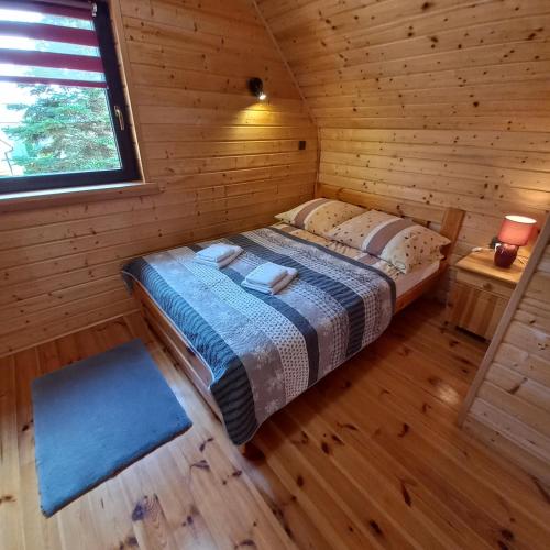 a bedroom with a bed in a wooden cabin at Domki Akwen in Rewal