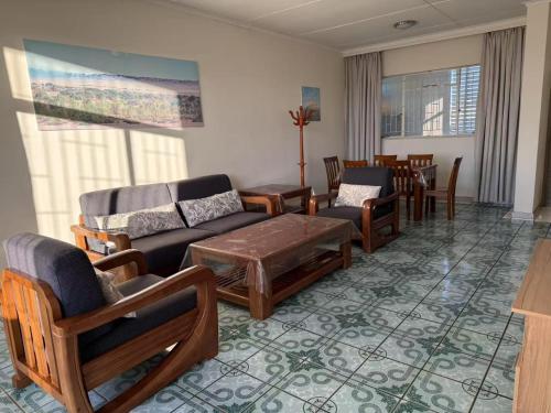 a living room with a couch and chairs and a table at Home Inn Self-Catering in Windhoek