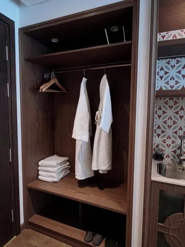 a closet with white towels and a sink at Apec Mandala Mũi Né Sun Sea Condotel in Mui Ne
