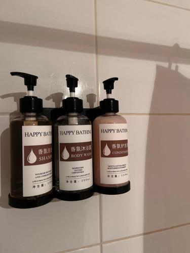 three bottles ofhappy bathroom products sitting on a shelf at Valle Nevado Ski Chill in 6Px in Farellones