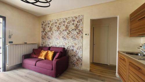 a purple couch in a living room with a wall at La Casa di Perla BILOCALE A 6 Kilometri da SALO' in Villanuova sul clisi