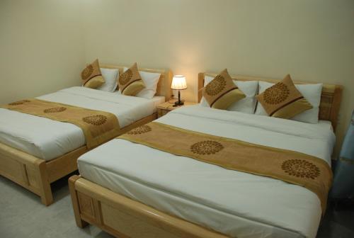 Un pat sau paturi într-o cameră la Khách sạn Quang Tuấn