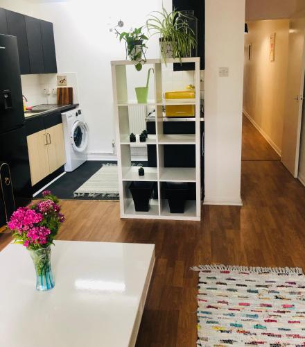 a living room with a table and a kitchen at Little apartment 20 min from central London in London