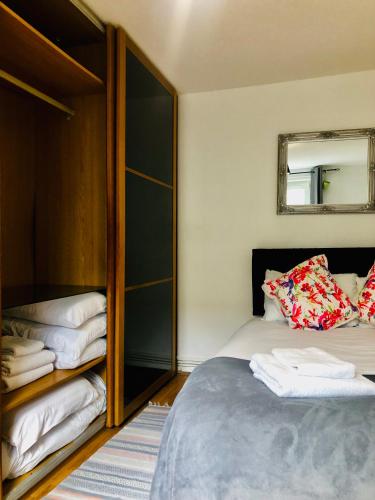 a bedroom with a bed and a mirror at Little apartment 20 min from central London in London