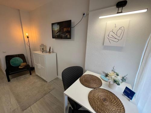 una habitación con una mesa blanca y una silla y una mesa sidx sidx en Apartment Coastal Feeling in Hercules Sea views, en Benalmádena