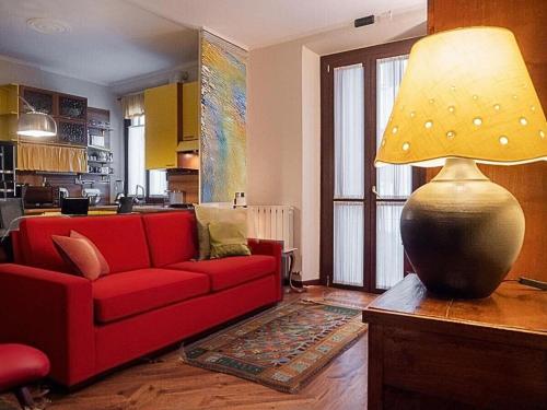 salon z czerwoną kanapą i lampą w obiekcie VFH Stylish Boutique Apartment-City Center w Mediolanie