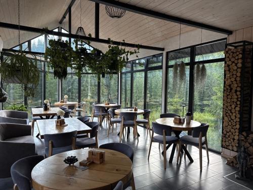 a restaurant with tables and chairs and windows at Шишка in Bukovel