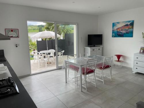 una cucina con tavolo e sedie e un patio di Appartement 48m2 jardin et terrasse a La Roche-Blanche