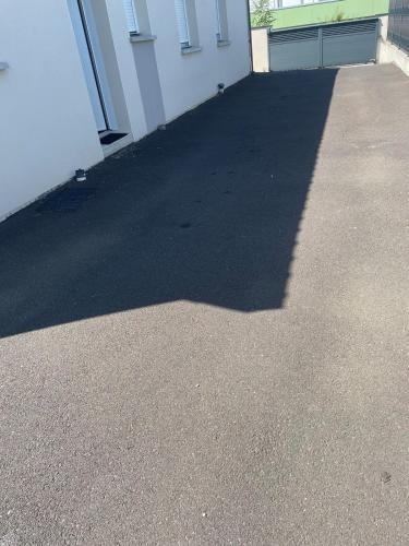 une ombre d'un bâtiment sur une allée dans l'établissement Appartement 48m2 jardin et terrasse, à La Roche-Blanche